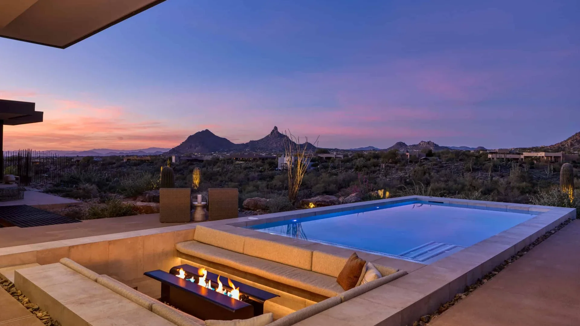 Stunning luxury pool remodel with LED lighting and water features at a Scottsdale home at dusk
